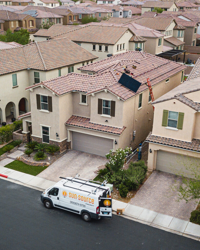 SunSource USA solar energy experts inspecting solar panels from above, captured in aerial drone shot.