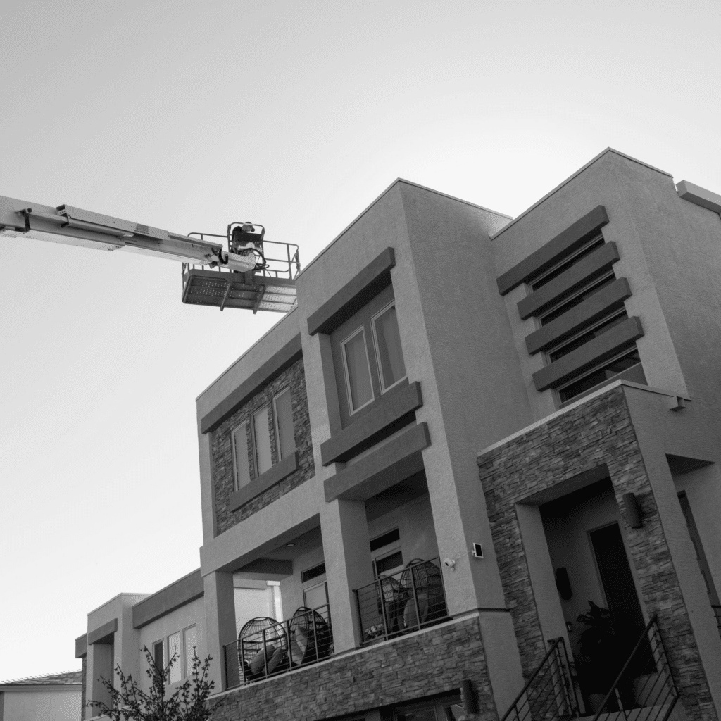 construction crane helping install solar panels on a residential home. 