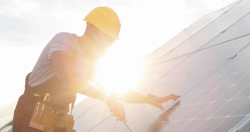 Solar installation being tightened on a rooftop.