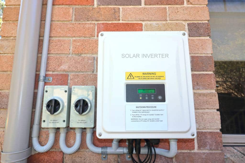 A solar inverter on the side of a home.