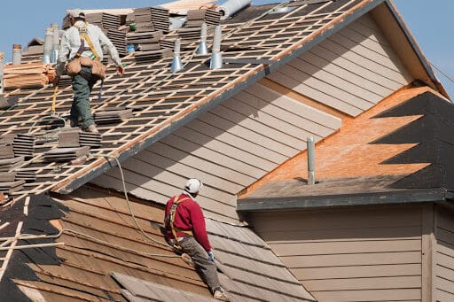 Workers reroofing a house